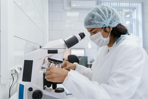 Chemist loading slides into a microscope.