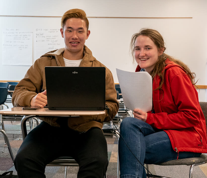 Tutor working with a student on a laptop